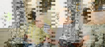 two adults sat next to each other on a sofa